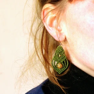 Boucle d'oreille en forme de goutte en micro-macramé vert olive, perles en jaspe paysage et laiton, zoom portée, cheveux roux