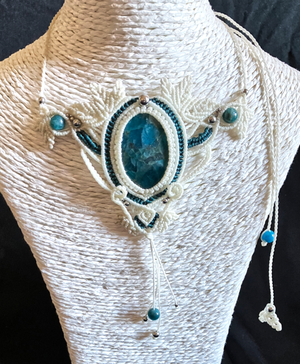 Zoom collier en micro-macramé blanc et émeraude, cabochon en apatite, perles en apatite et acier inoxydable, motifs feuilles, sur présentoir neutre