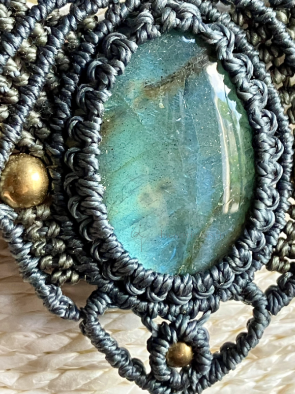 Zoom sur le cabochon en labradorite d'un collier en micro-macramé anthracite et khaki, perles en laiton