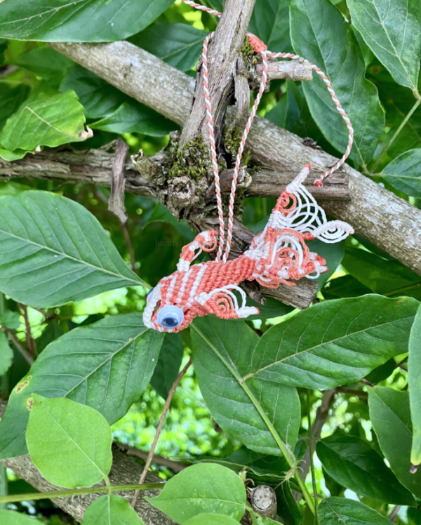Suspension en micro-macramé 3D, vue de côté, carpe koï orange terracotta et blanc avec yeux mobiles, arrière plan végétation