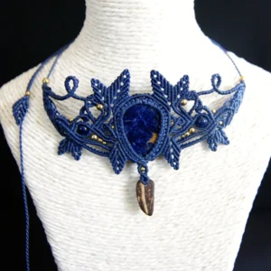 Collier en micro-macramé bleu marine, cabochon sodalite, perles lapis lazuli et laiton, morceau de coque de noix de coco, motifs feuilles, zoom de face sur présentoir neutre, fond noir