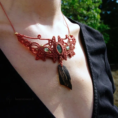 Collier en micro-macramé orange cannelle, motifs feuilles, cabochon unakite, perles en aventurine et laiton, morceau de coque de noix de coco, vue 3/4 porté, arrière plan végétation