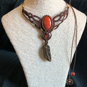 Collier en micro-macramé marron acajou, cabochon jaspe rouge, perles en cornaline et laiton, breloque en coque de noix de coco, présenté sur un support neutre