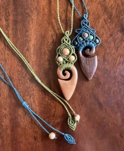 2 pendentifs en micro-macramé et élément bois massif, sur une table en bois