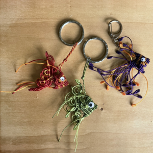 3 porte-clefs poissons triangulaires en micro-macramé 3D, vue de côté, rouge et topaze, vert citron et khaki, violet et topaze, avec yeux mobiles et anneaux en acier inoxydable