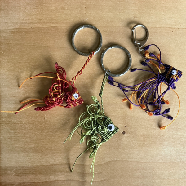 3 porte-clefs poissons triangulaires en micro-macramé 3D, vue de côté, rouge et topaze, vert citron et khaki, violet et topaze, avec yeux mobiles et anneaux en acier inoxydable