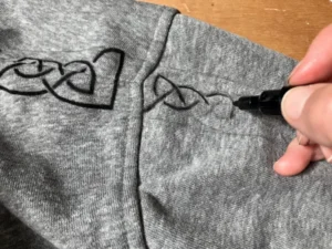 Zoom personnalisation sweat homme, frise celtique au posca noir en cours