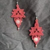 Photo boucles d'oreilles aux motifs feuilles et entrelacs en micro-macramé rose framboise, perles en quartz rose, perles et crochets en acier inoxydable, accrochées sur un tissu noir