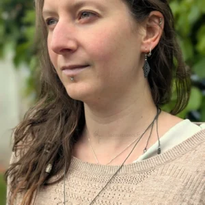 Photo portrait femme de 3/4 portant le pendentif et les boucles d'oreilles Pétiole vert khaki