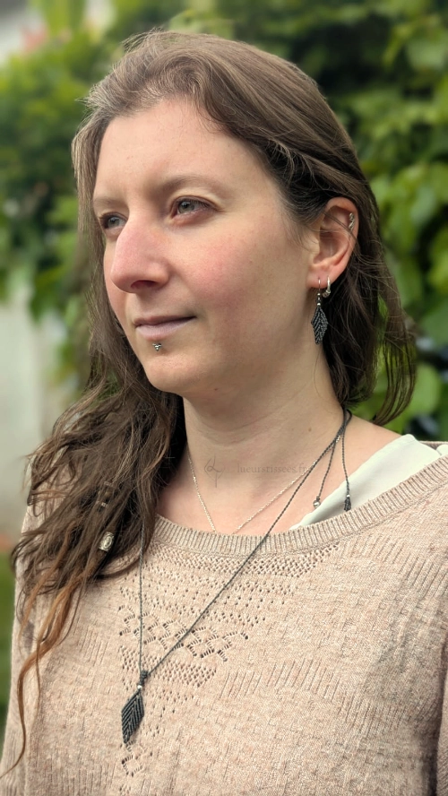 Photo portrait femme de 3/4 portant le pendentif et les boucles d'oreilles Pétiole vert khaki