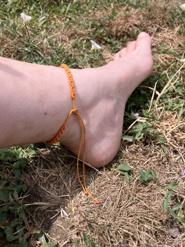 BC_simple-topaze-étoile02 Photo bracelet de cheville en micro-macramé topaze, zoom sur le nœud coulissant, porté, arrière plan herbe
